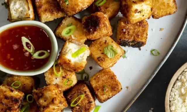 Krispiga, gyllene tofu-bitar serveras med en söt chilisås. Ett perfekt tofu recept för en snabb och god måltid.