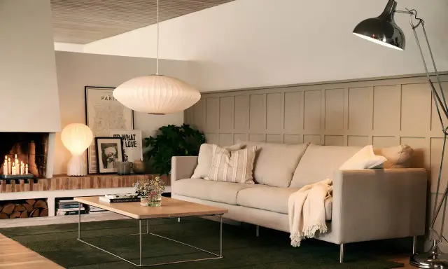 En inbjudande soffgrupp med en bekväm soffa, ett lågt soffbord och en mysig brasa.