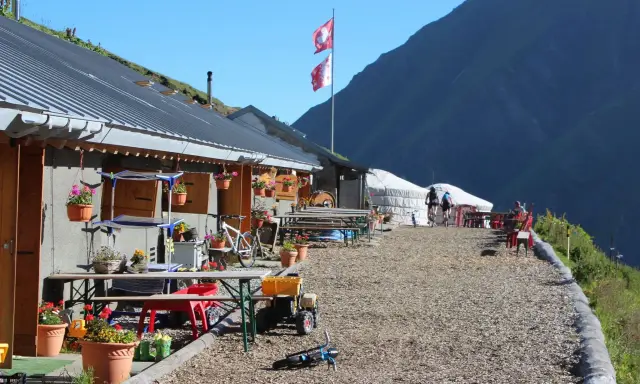 Górskie schronisko, idealne na przerwę podczas tour de Mont Blanc. Dwa rowery, szwajcarskie flagi i piękne widoki.