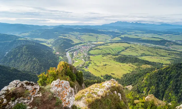 Widok z góry na dolinę z rzeką i miasteczkiem, w oddali majaczą Tatry. Trzy Korony w pełnej krasie.