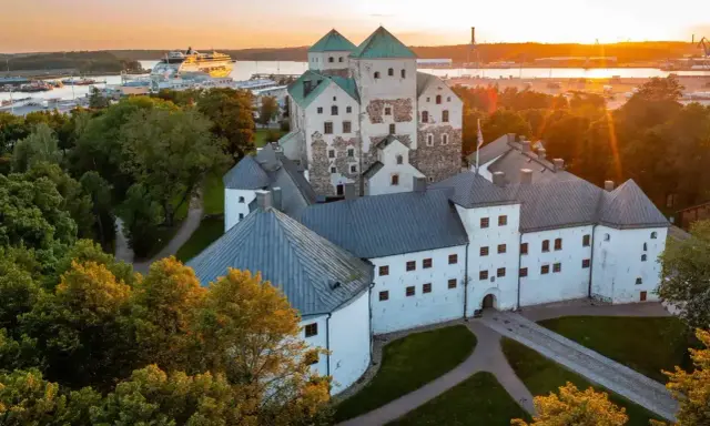 Zamek w Turku, jeden z głównych punktów, turku co zobaczyć, o zachodzie słońca. W tle port z wycieczkowcem.