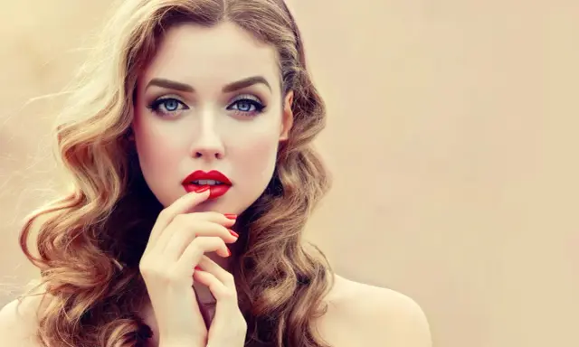 Glamouröse Frau mit voluminösen, welligen Haaren und roten Lippen. So gelingen Hollywood Waves selber machen!