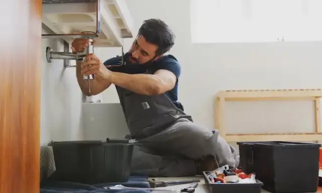 Fontanero arregla un grifo con fugas, un ejemplo de jurisprudencia sobre pequeñas reparaciones de alquiler.