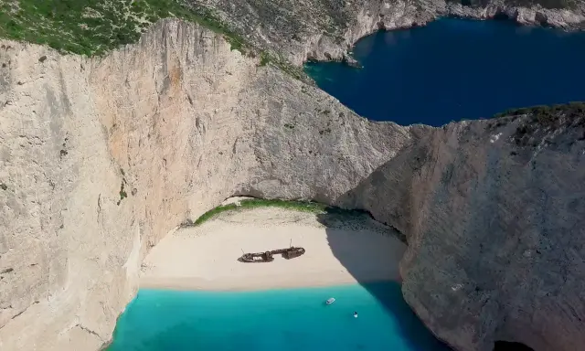 Navagio, jedna z najpiękniejszych plaż Zakynthos, z wrakiem statku na białym piasku i turkusową wodą.