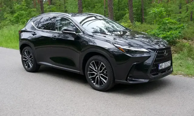 Lśniący czarny Lexus NX 2025 na tle zielonego lasu. Elegancki SUV gotowy na przygodę.