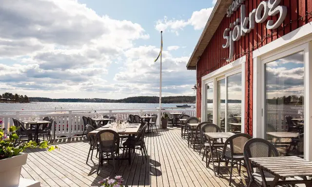 Välkommen till en restaurang vid vattnet i Stockholm! Njut av utsikten över skärgården från en av de många borden på trädäcket.