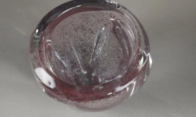 Un bol en verre soufflé, aux reflets pourpres et inclusions, évoquant l'art de André Thuret.