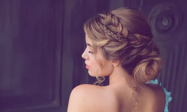 Elegante Frisur für Hochzeitsgäste: Ein kunstvoller Dutt mit geflochtenen Akzenten und zarten Locken.