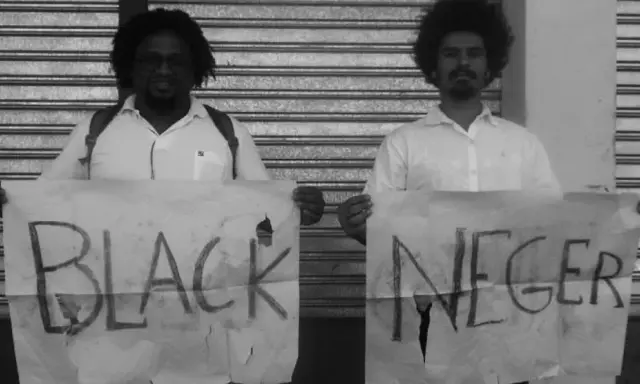 Dwóch mężczyzn trzyma transparenty z napisem "BLACK NEGER". Czy to wyraz buntu, czy prowokacja kwestionująca poprawność polityczną?