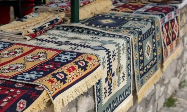 Kolorowe, tradycyjne kilimy z frędzlami. Idealne pamiątki, by poczuć klimat Albanii. Co przywieźć z Albanii? Taki kilim!