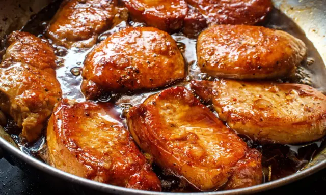 Filet mignon en train de dorer dans une poêle, leur marinade caramélisée créant une sauce appétissante.
