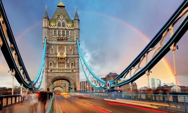 Tower Bridge in London, a city renowned for its art, glows under a double rainbow at dusk.