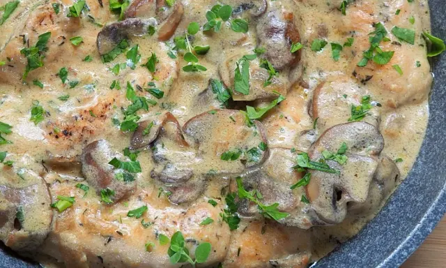 Polędwiczki w sosie pieczarkowym, kremowe i aromatyczne, posypane świeżą natką pietruszki.
