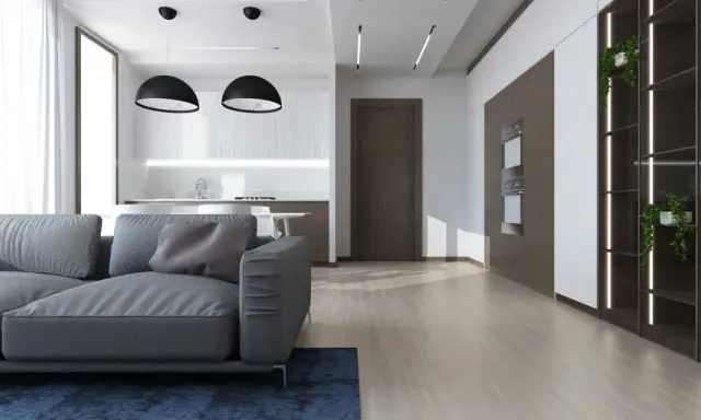 Soggiorno moderno con divano grigio, cucina a vista e scaffalatura illuminata. Ottime idee controsoffitto open space per definire gli ambienti.