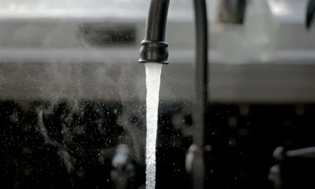 Un robinet ouvert, l'eau coule. Une image symbolisant l'ouverture du compteur d'eau pour un locataire.