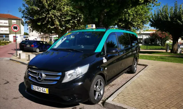 Schwarzer Mercedes-Taxi-Van mit türkisfarbenem Dach in Lissabon. Informieren Sie sich über die Taxi Lissabon Kosten für Ihre Fahrt.