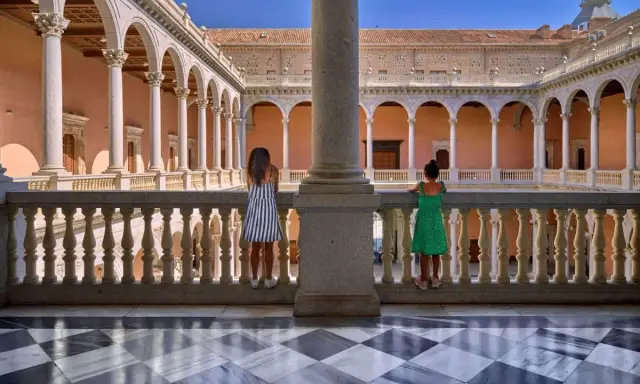 Dos niñas contemplan la arquitectura de un patio toledano. ¿Qué hacer hoy en Toledo? Explorar este lugar histórico.