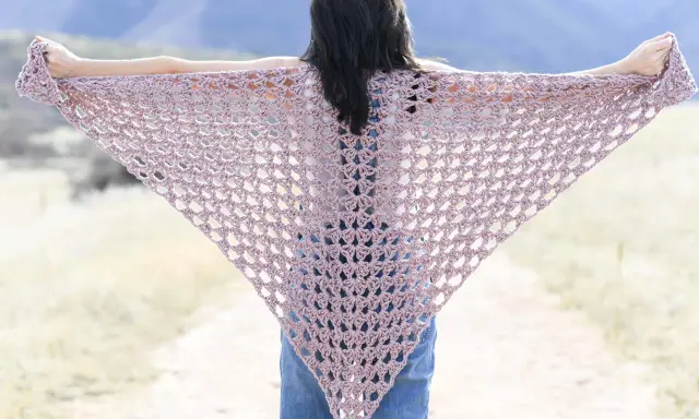 Chal triangular de crochet en tono rosa pálido, ideal para un patrón chal crochet facil.