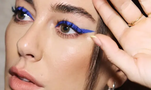 Ojos azules y piel blanca realzados con un audaz delineado azul eléctrico.