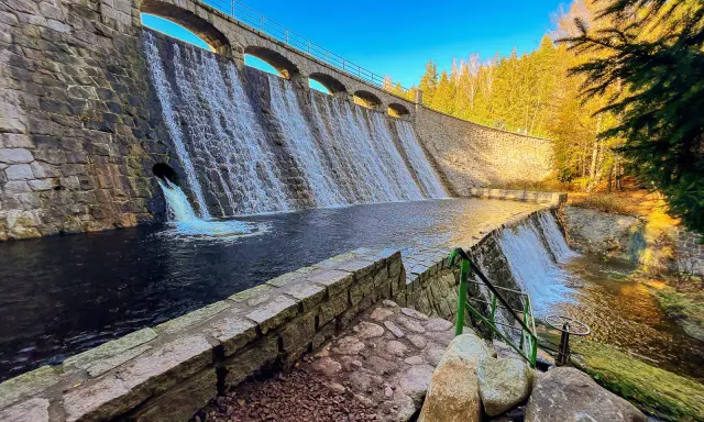 Zapora w Karpaczu, otoczona jesiennymi lasami, przypomina o potędze gór.