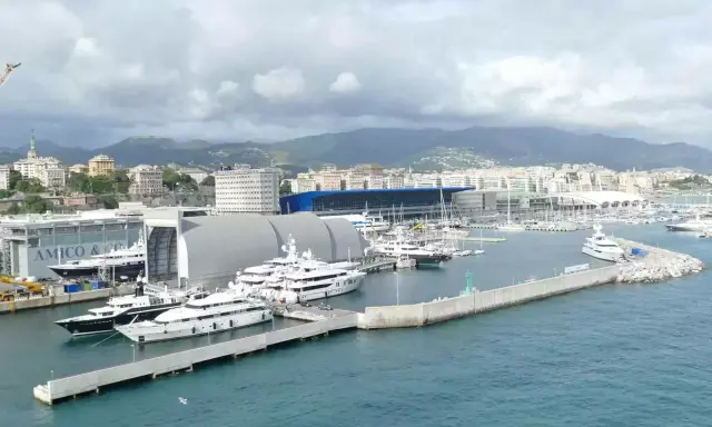 Porto con yacht di lusso ormeggiati, sullo sfondo la città e le montagne. Un'immagine che fa sognare, ma il costo medio crociera è da valutare.