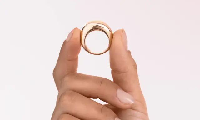 Dita che mostrano un anello in oro 18k 0.750, un gioiello elegante e moderno.