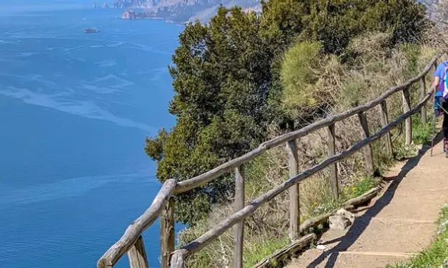 Escursionista sul sentiero degli dei ad Agerola, con vista mozzafiato sul mare blu e le isole.