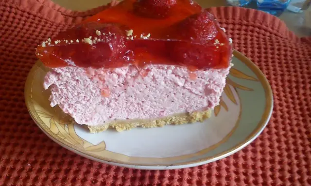 Pyszna pianka truskawkowa z galaretką i owocami, podana na talerzyku.