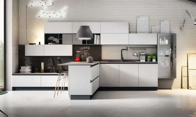 Cucina moderna con isola centrale, pensili bianchi e lavagna con scritta "cooking in your kitchen". Ottima pittura lavabile cucina, opinioni positive per la praticità.