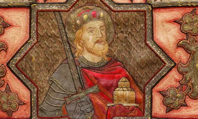 Ein König mit Krone und Bart, der ein Schwert und ein Gebäude hält, umgeben von Ornamenten. Möglicherweise eine Darstellung aus dem Jahr 800 nach Christus.