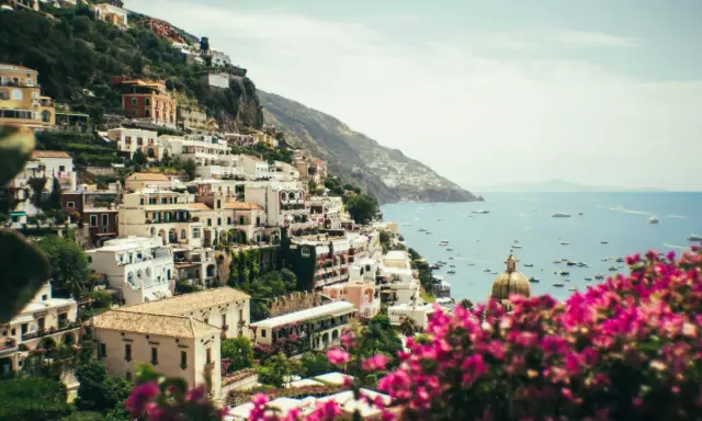 Positano, uno dei paesi più belli della Costiera Amalfitana, con case bianche aggrappate alla scogliera e il mare blu pieno di barche.