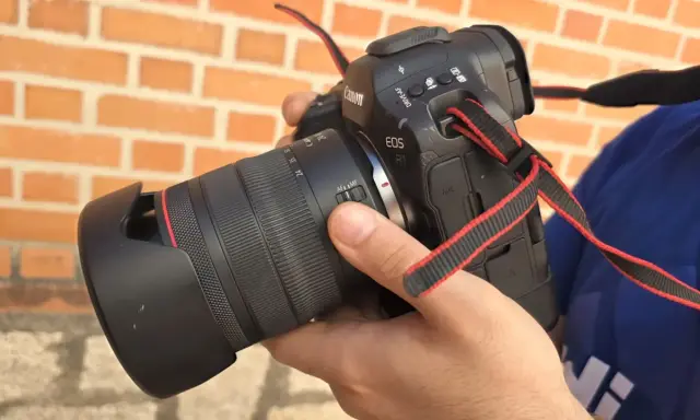 Mano sosteniendo una cámara Canon R1 con lente, lista para capturar momentos.