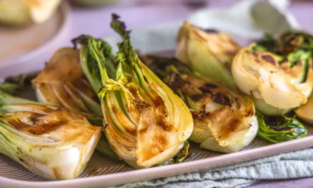 Halbierte Pak Choi-Stücke, die auf einem Teller mit Grillspuren liegen. Köstlich und gesund!