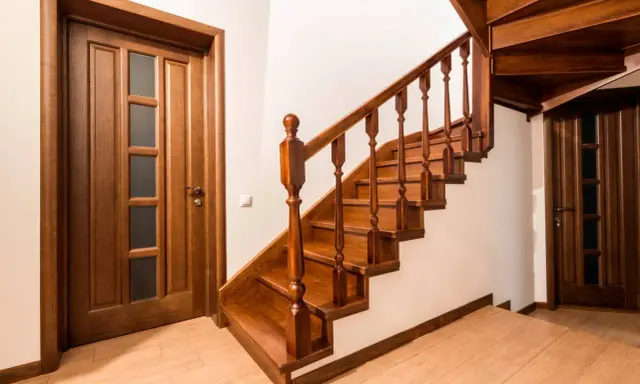 Scala interna in legno scuro con porte abbinate. Idee pittura scala interna: il legno caldo crea un'atmosfera accogliente.