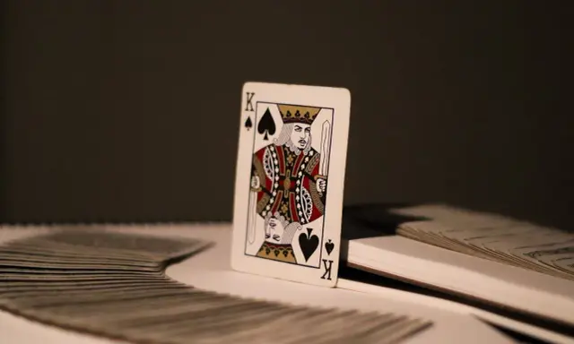 Król pik znaczenie. Pojedyncza karta, król pik, stoi na stosie kart.