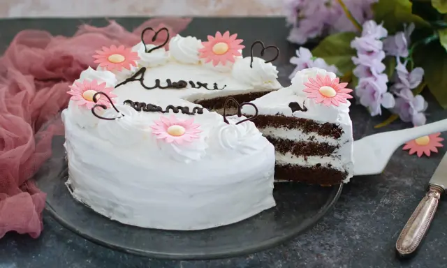 Torta decorata con fiori rosa e scritte in cioccolato, perfetta per la torta festa della mamma. Un dolce per celebrare con amore.