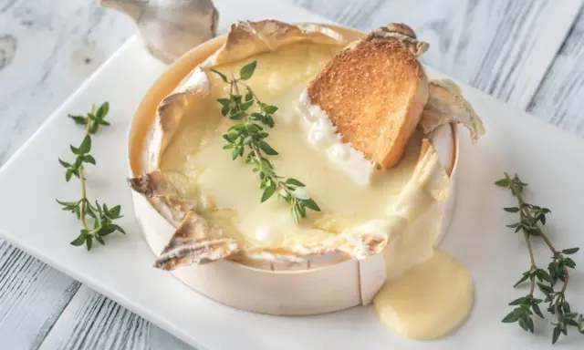 Un camembert coulant, spécialité normandie, servi avec du pain grillé et du thym. Un délice !