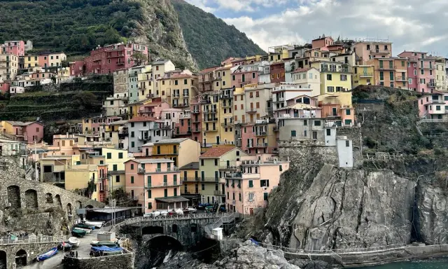 Case colorate aggrappate alla roccia, un paesaggio da cartolina. Cinque blues per la banda Monterossi, un'armonia di tinte vivaci che abbraccia il mare.