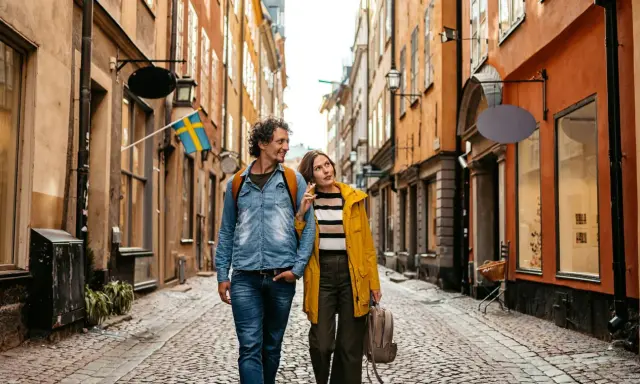 Ein Paar spaziert durch eine Gasse in Stockholm. Das Wetter in Schweden im September ist mild, perfekt für Sightseeing.