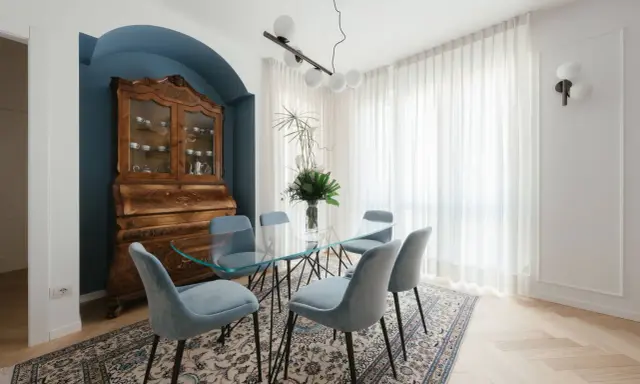 Un soggiorno classico con un mobile antico e un tavolo in vetro. I colori delle pareti, un blu intenso, creano un'atmosfera elegante.