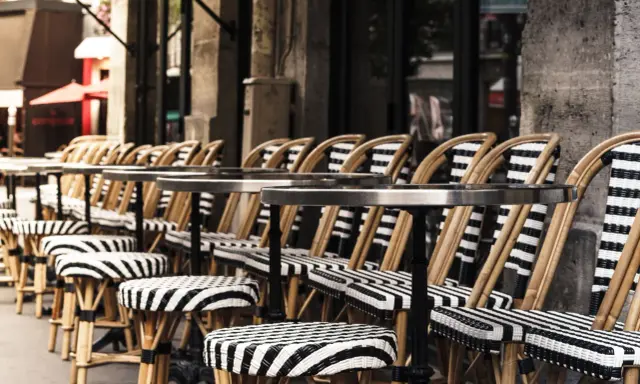 Terrasses parisiennes avec chaises et tabourets rayés, prêts à accueillir les gourmands pour déguster les spécialités paris.
