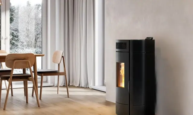 Poêle à granulés noir moderne, offrant une puissance de chauffage idéale pour un salon cosy. La flamme visible promet une ambiance chaleureuse.