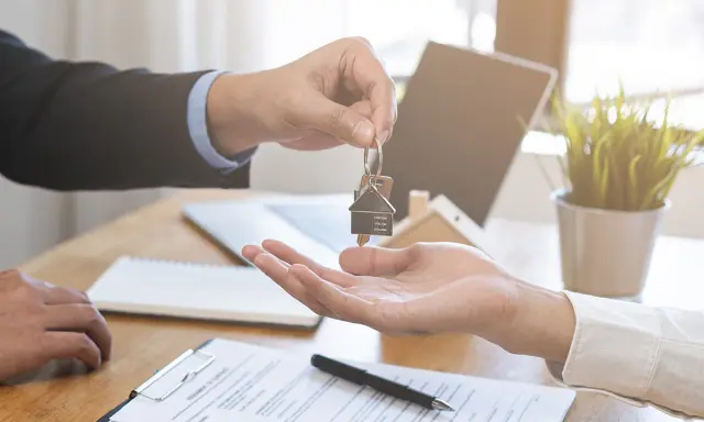Entrega de llaves de un piso de alquiler. El agente inmobiliario da las llaves a un cliente. Ahora puedo echar a mi pareja del piso de alquiler.