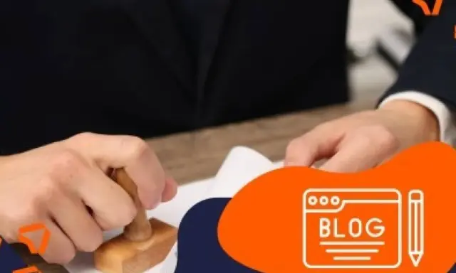 Persona con traje sella un documento, quizás para tramitar un carnet conducir. Icono de blog al lado.