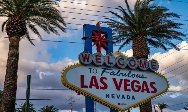 Słynny znak "Welcome to Fabulous Las Vegas" w Nevadzie, stan, w którym znajduje się to miasto rozrywki, otoczony palmami.