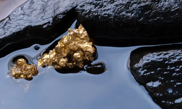 Oro grezzo, scintillante tra rocce scure e acqua limpida. Un'immagine che evoca il mistero di come nasce l'oro.