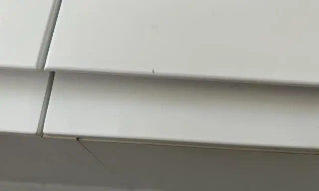 Detalle de un mueble lacado blanco con pequeños arañazos, listo para reparar.