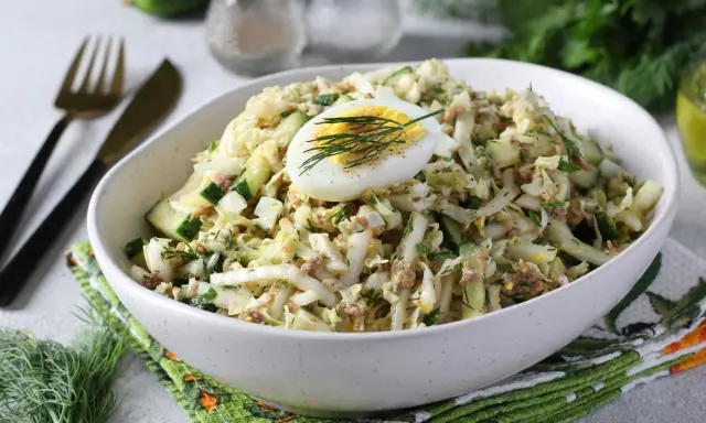 Lekka sałatka z tuńczykiem, jajkiem i ogórkiem, udekorowana koperkiem. Idealna na szybki lunch.