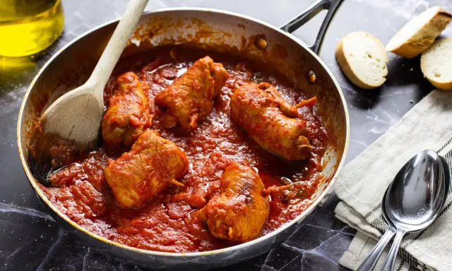 Braciola pugliese in padella con sugo rosso, pronte per essere gustate con pane fresco.