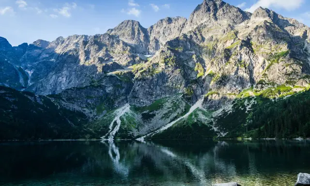 Morskie Oko, Tatry. Majestatyczne góry odbijają się w krystalicznie czystej wodzie, ukazując głębokość jeziora.